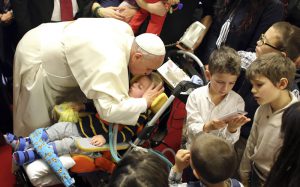 Pope Francis kisses a disabled child during a visit to the parish of Santa Maria dell'Orazione on the outskirts of Rome March 16. (CNS photo/Stefano Rellandini, pool via Reuters) (March 17, 2014) See POPE-PARISH March 17, 2014.