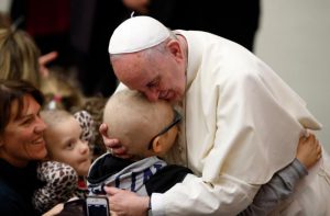 Pope Francis embraces a child as he meets the disabled during his general audience in Paul VI hall at the Vatican Jan. 13. (CNS photo/Paul Haring) See POPE-AUDIENCE-MERCY Jan. 13, 2016.